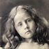 "The Anniversary." portrait en buste d'une petite fille en studio, penchant la tête, les mains jointes sur son buste nu